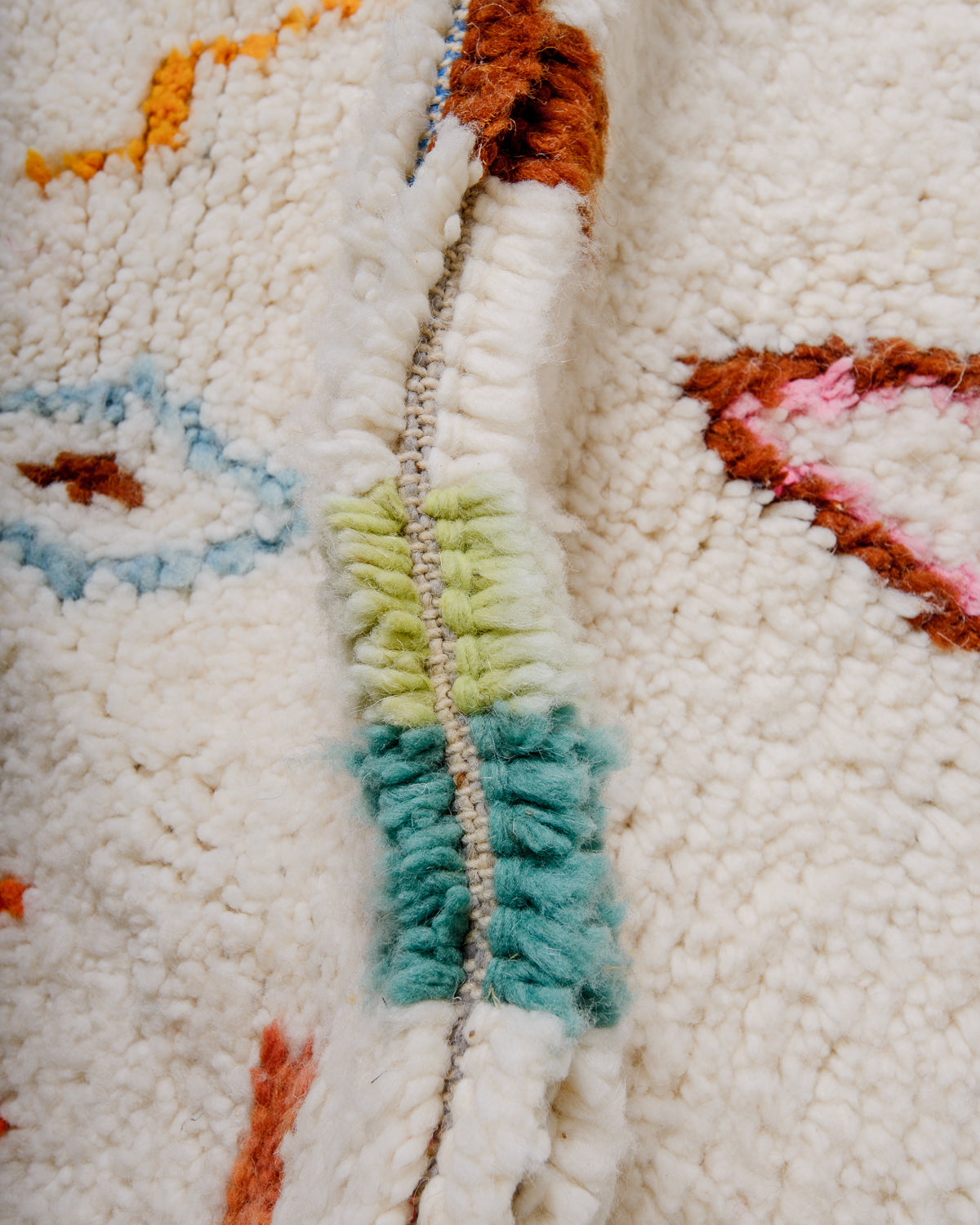 Detail of wool berber rug showing depth of pile and different coloured wool used. 
