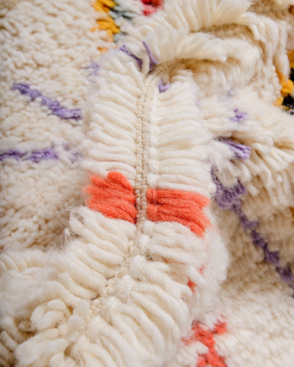 Detail of fluffy  wool in cream, yellow, lavender and coral.