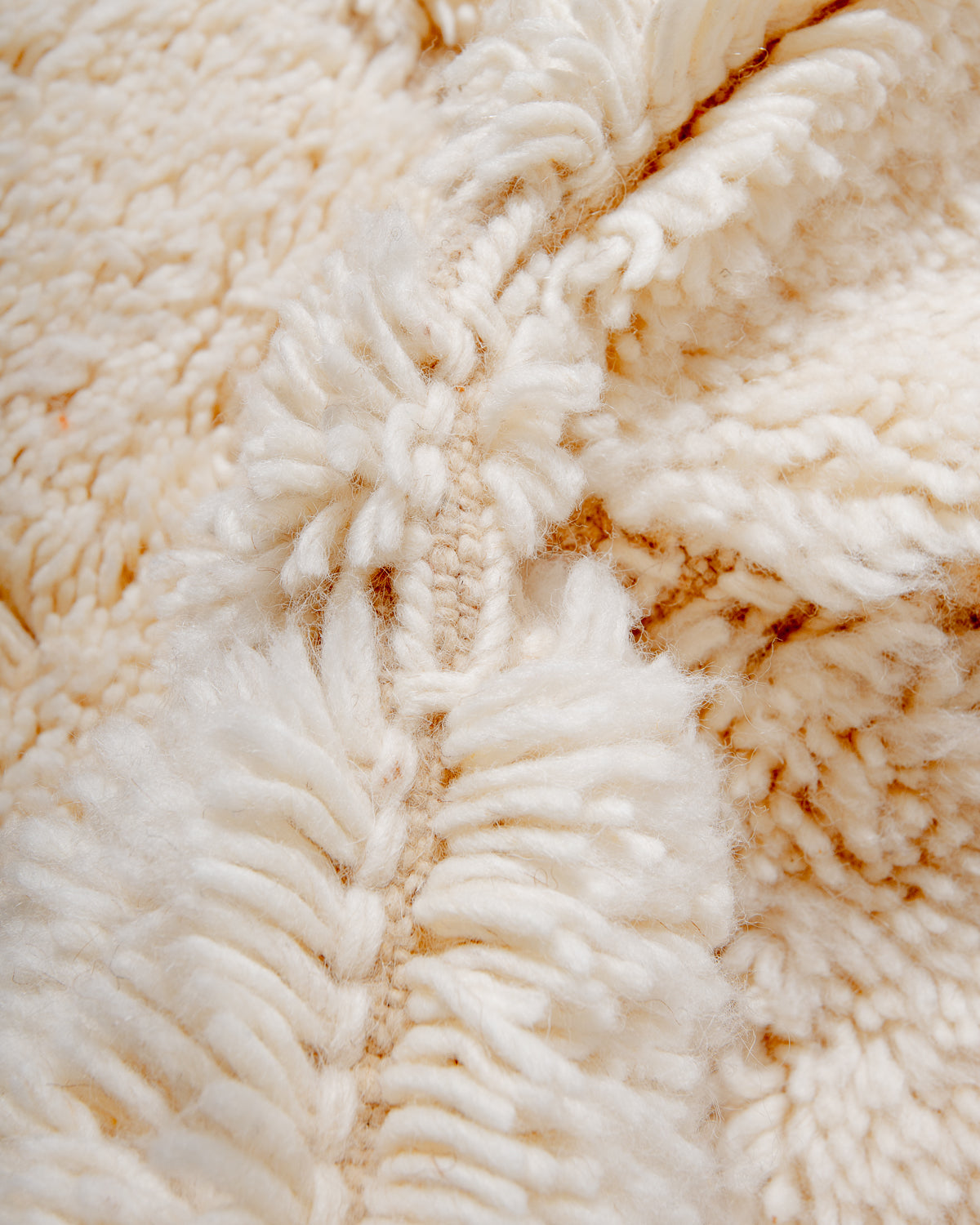 Close up of fluffy cream wool pile of Beniourain rug.