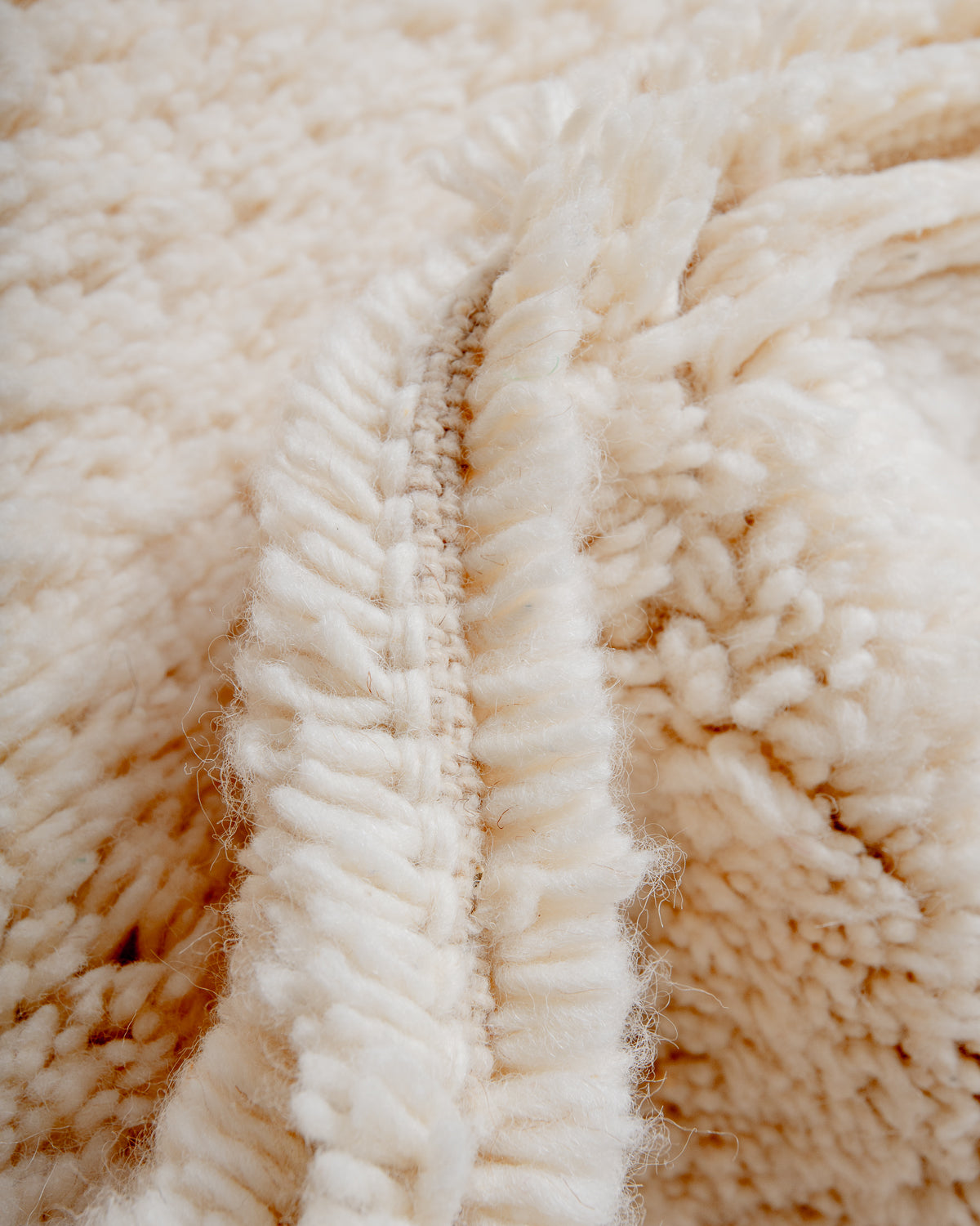 Close up of fluffy cream wool pile of Beniourain rug.