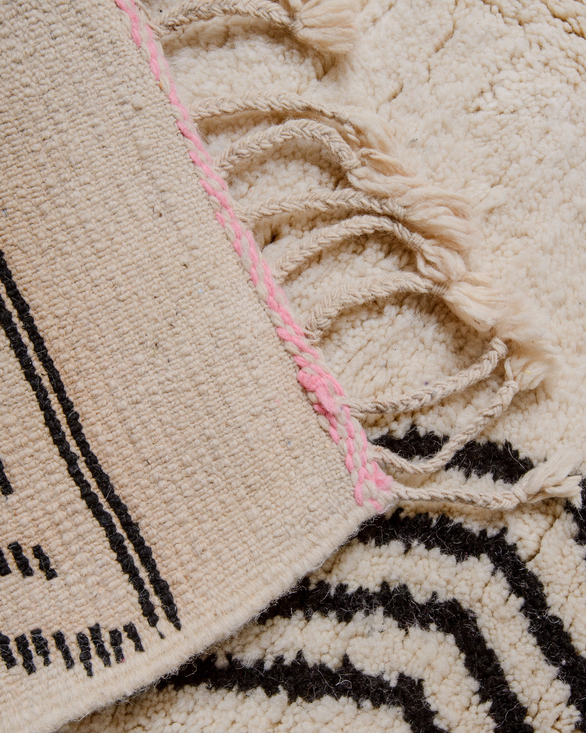 Corner of rug folded over to show the back and density of rows of knots. 