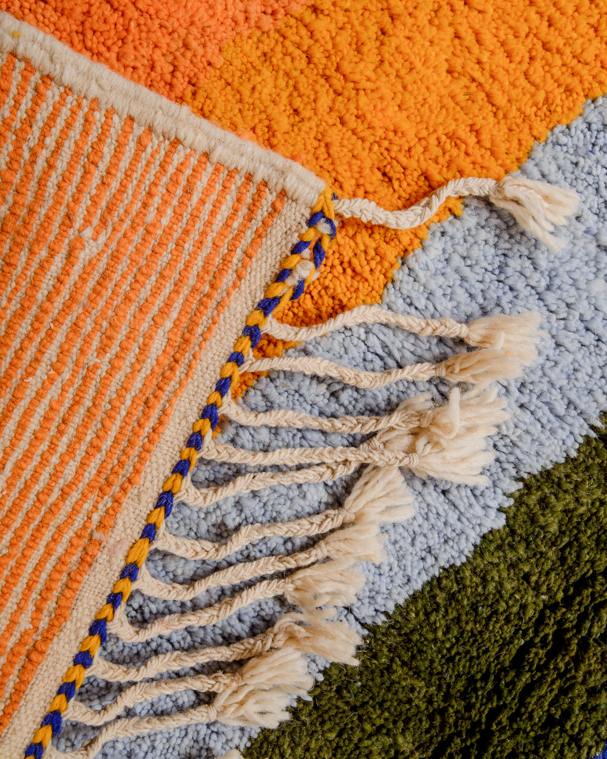 Corner of rug folded over to show the back and density of rows of knots. 