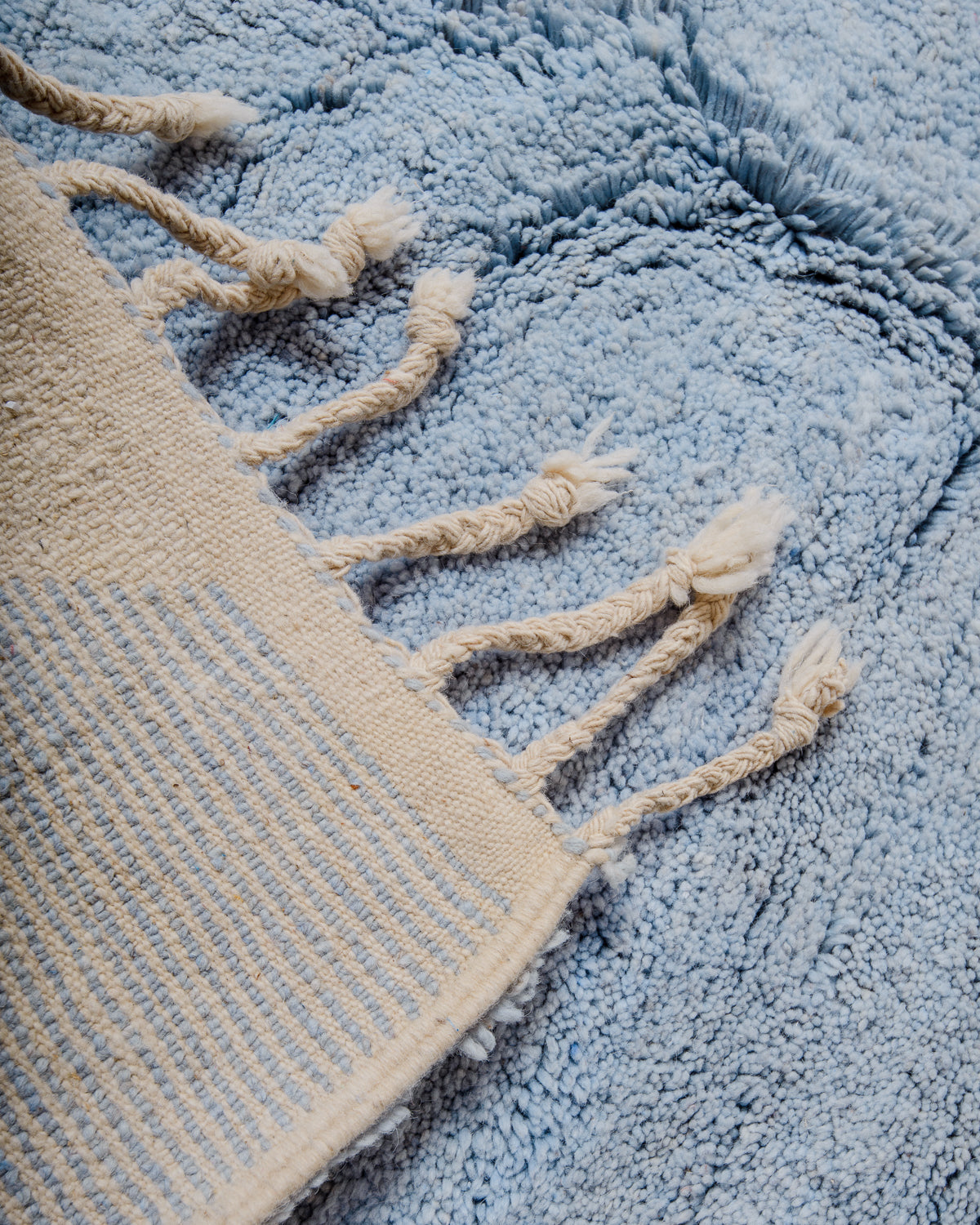 Corner of rug folded over to show the back and density of rows of knots. 