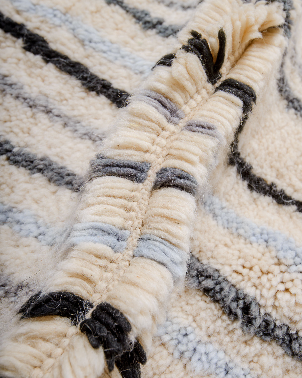 Detail of wool of Berberlin finest Beniourain rug showing thick wool pile and dense knots.