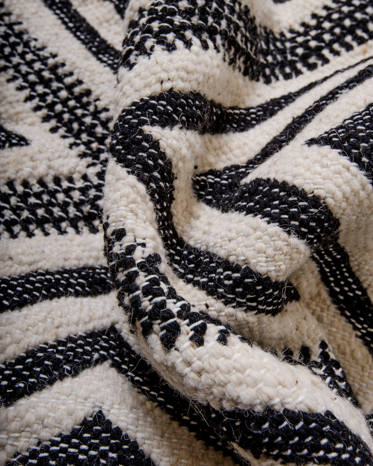 Detail of flat-woven wool Kelim rug in black and white.