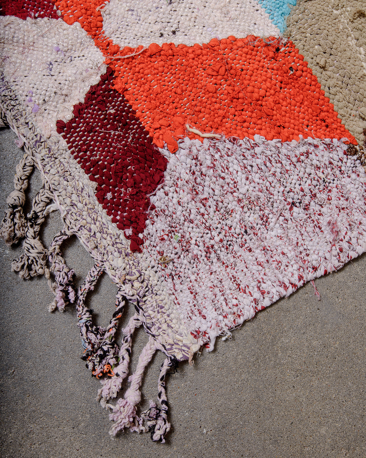 Corner of vintage Kelim rug with cotton tassels.