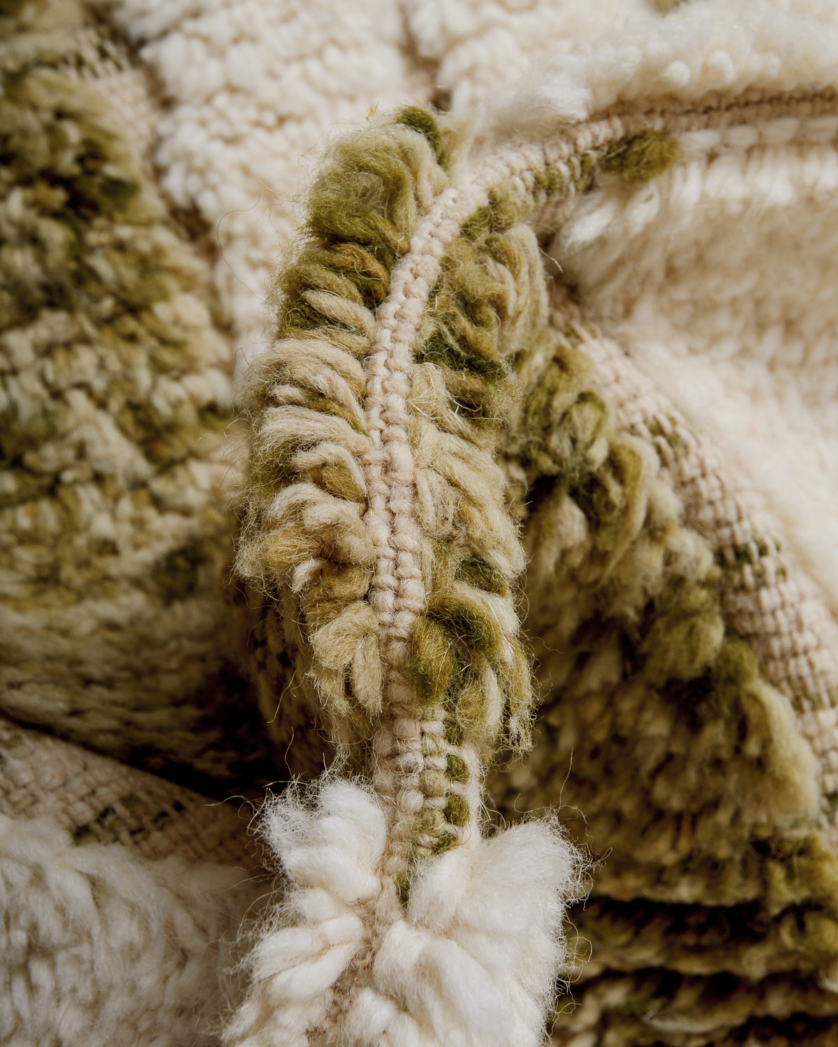 Close up of fluffy cream wool pile of Beniourain rug.