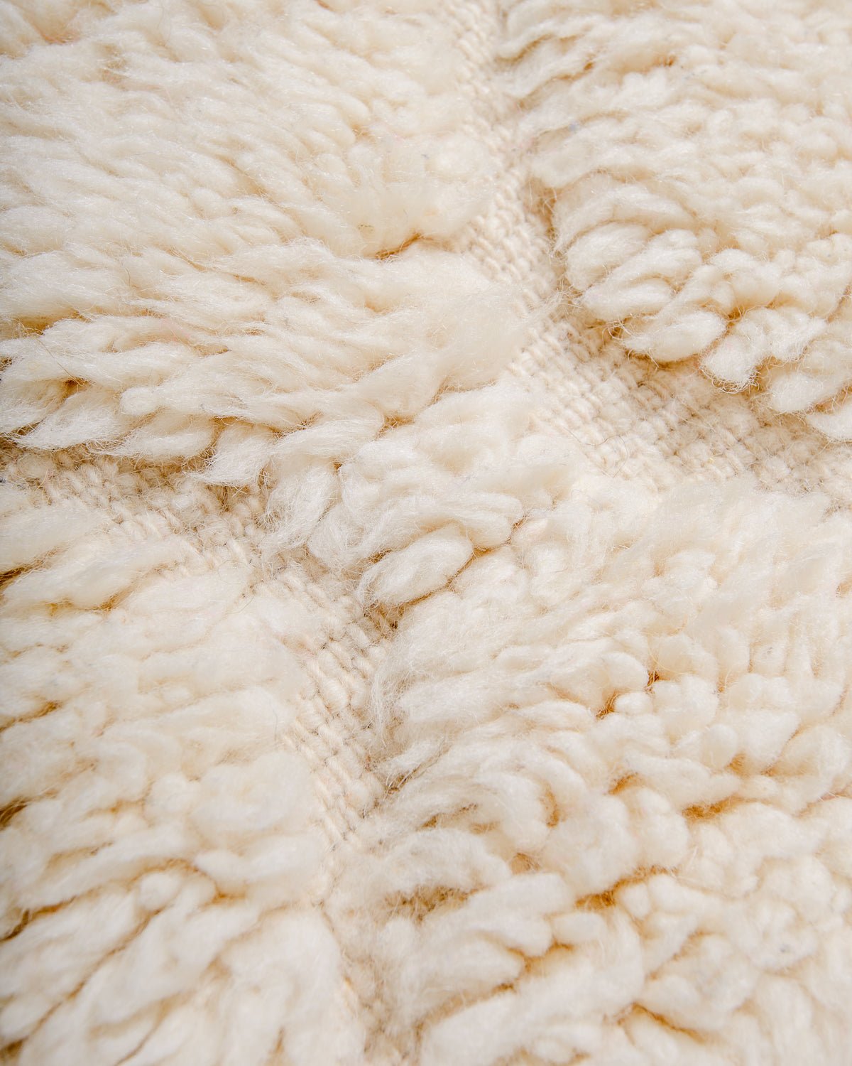 Close up of fluffy cream wool pile of Beniourain rug.