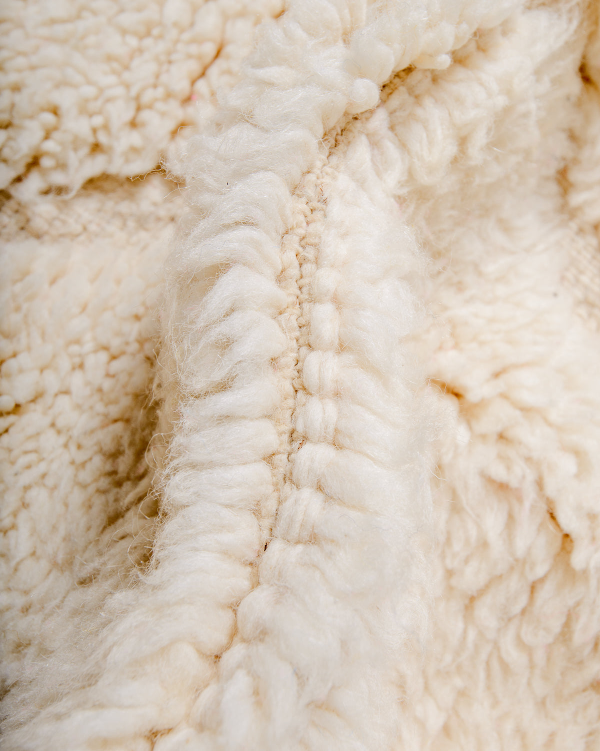Close up of fluffy cream wool pile of Beniourain rug.