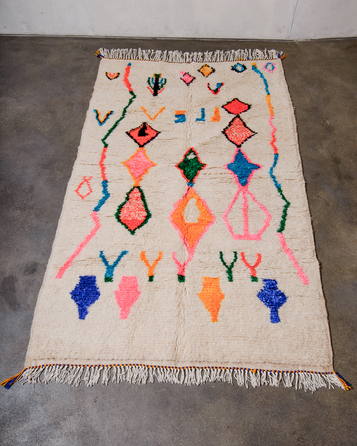 Berberlin Azilal rug made of fluffy wool and cotton, laying flat on a concrete floor. 