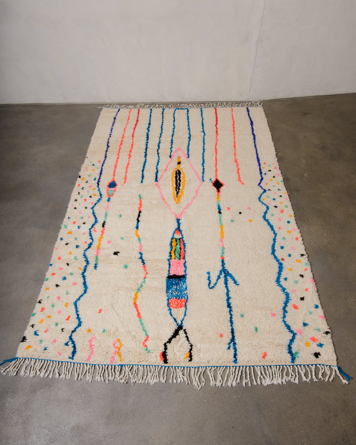 Berberlin Azilal rug made of fluffy wool and cotton, laying flat on a concrete floor. 