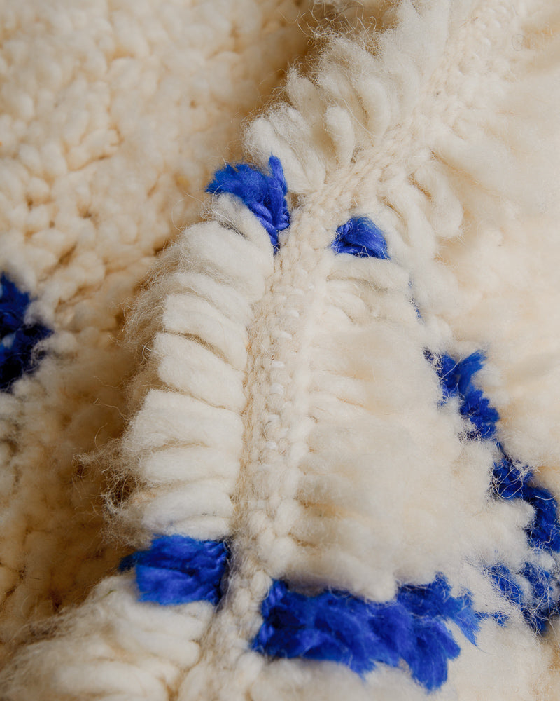Close up of Berberlin Azilal rug with cream sheep's wool and soft blue cotton.