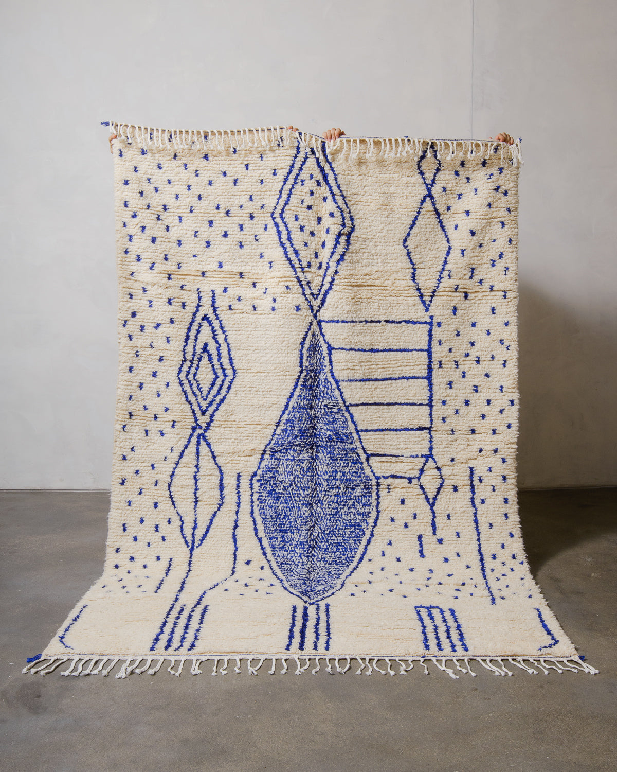 Handmade rug with blue geometric patterns on a plain background