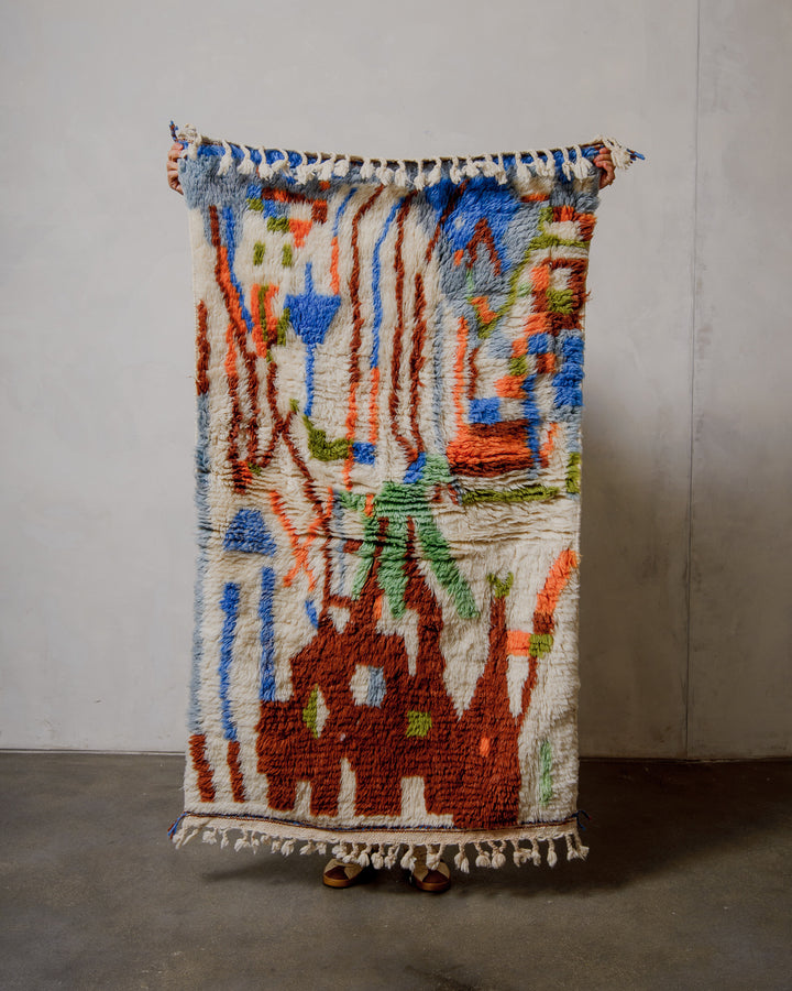 Colorful woven rug with abstract patterns on a plain background