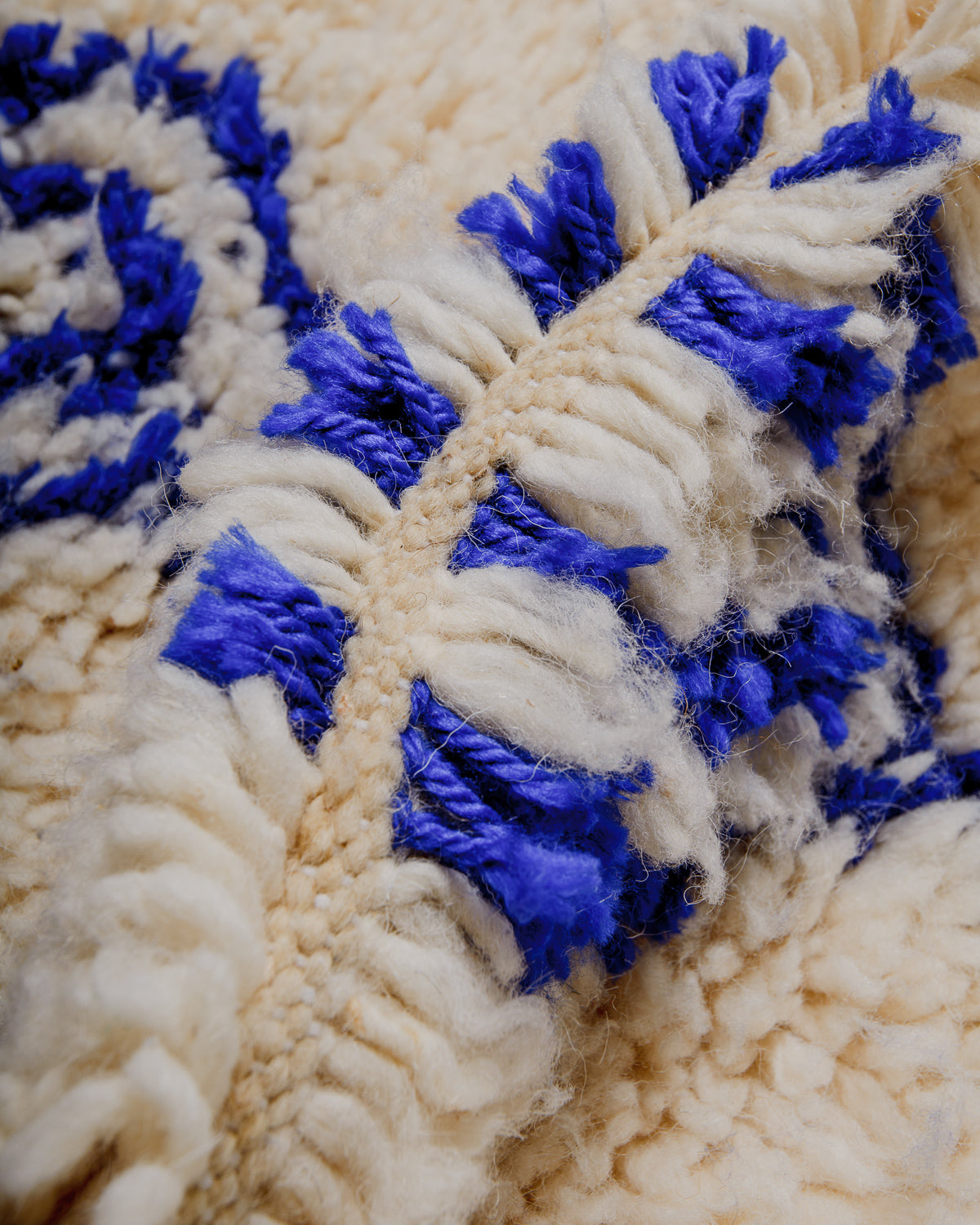 Close-up of a textured wool rug with blue and cream pattern