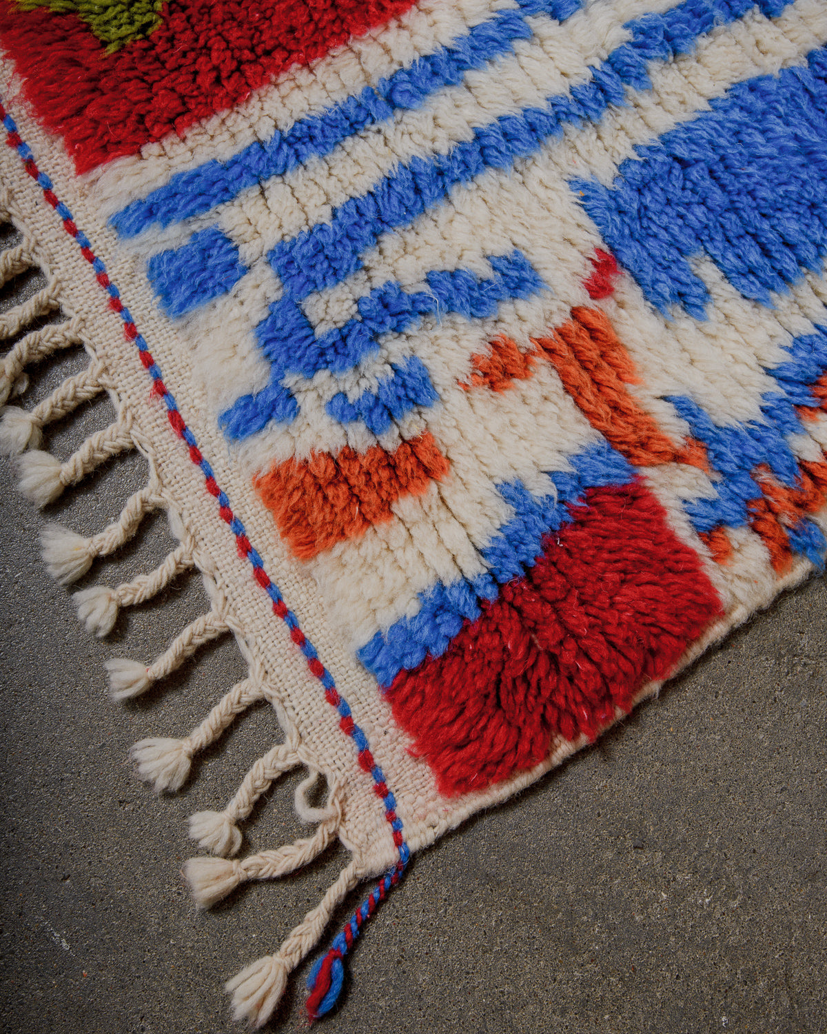 Colourful woven rug with geometric pattern on a concrete surface