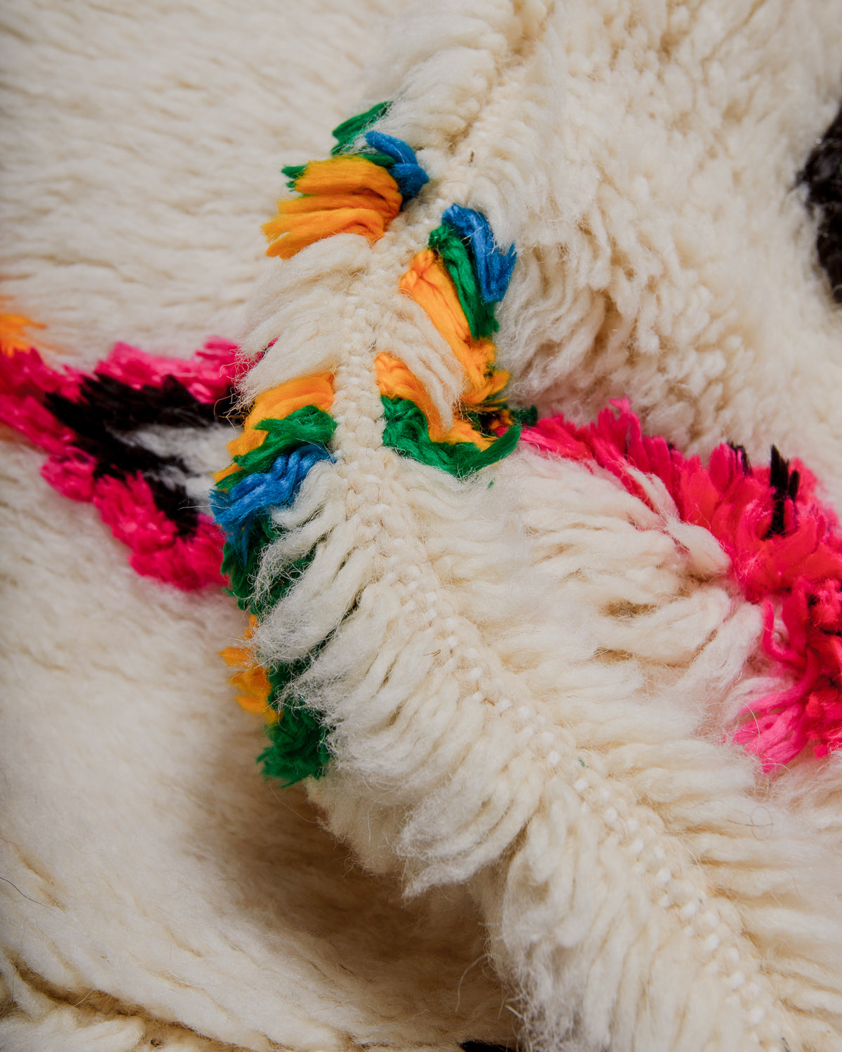 Close-up of a textured wool rug with colourful yarn patterns