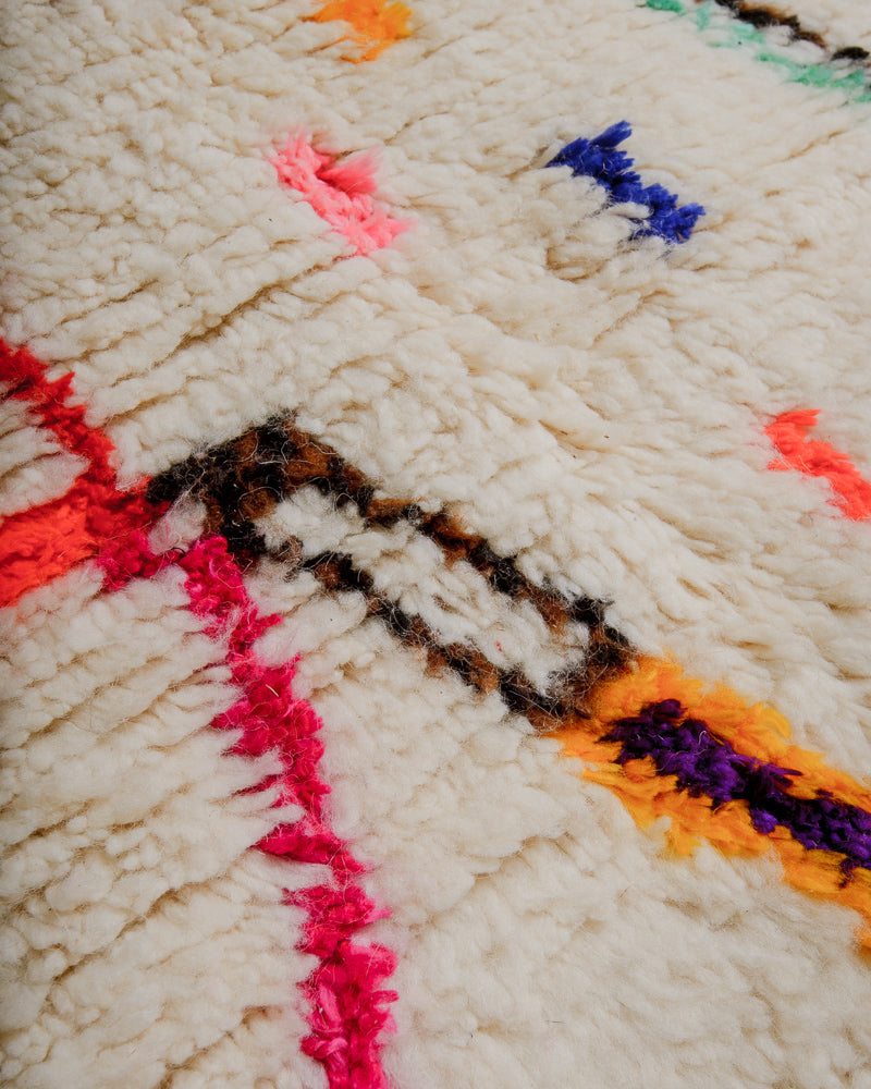 Surface of rug with colourful cotton in  pink, yellow and brown.