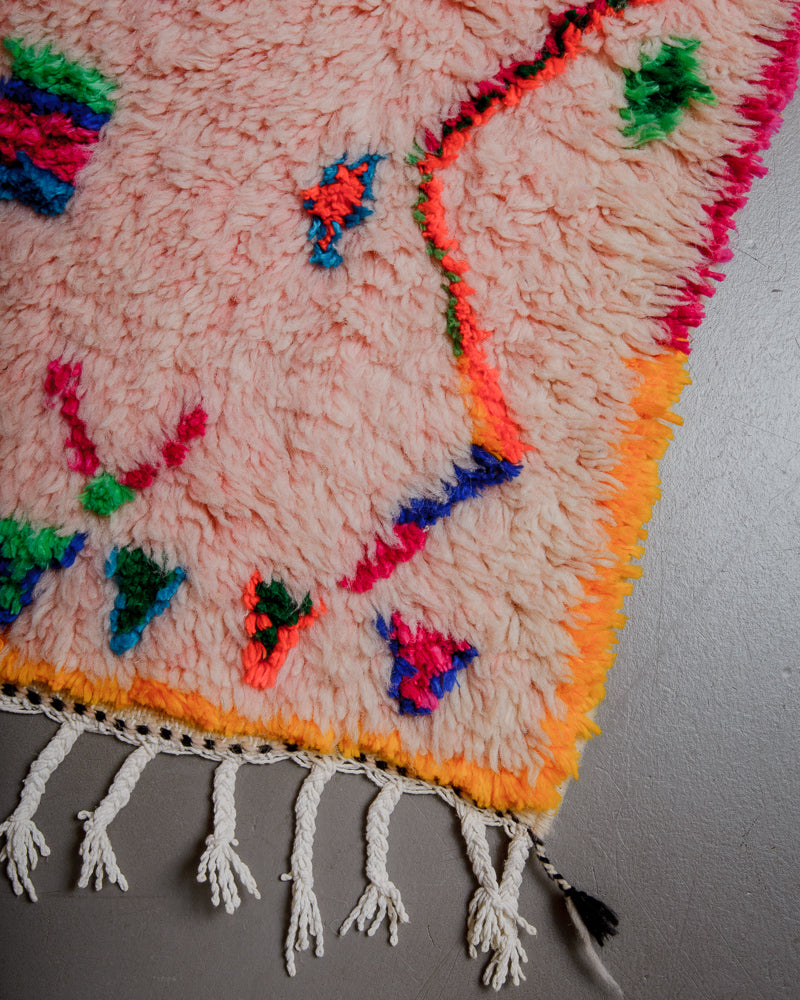 Corner of Berberlin Azilal rug with rose coloured wool and colourful cotton and white cotton tassels.