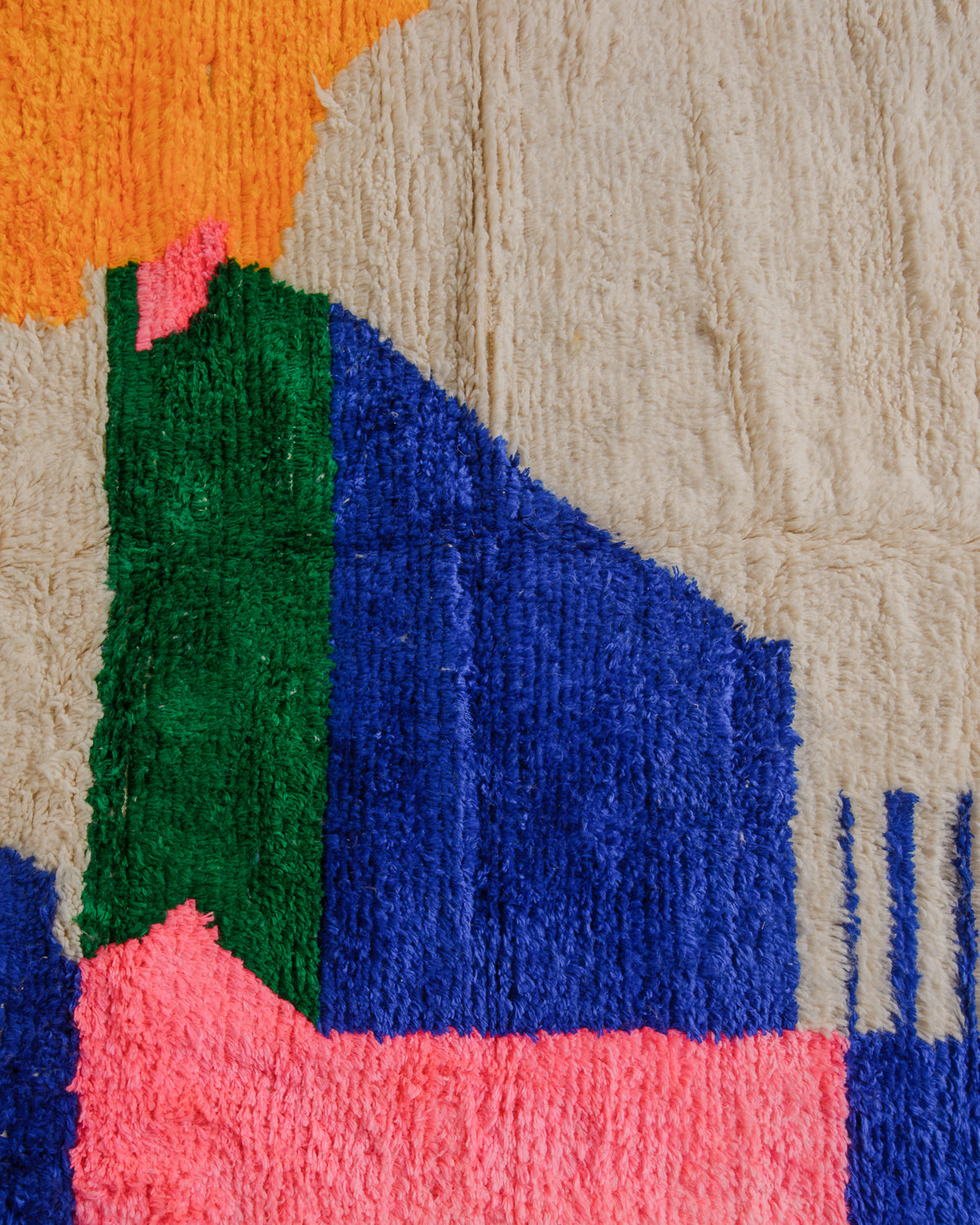 Surface of Azilal rug with cream and bold blue, green, pink and yellow. 