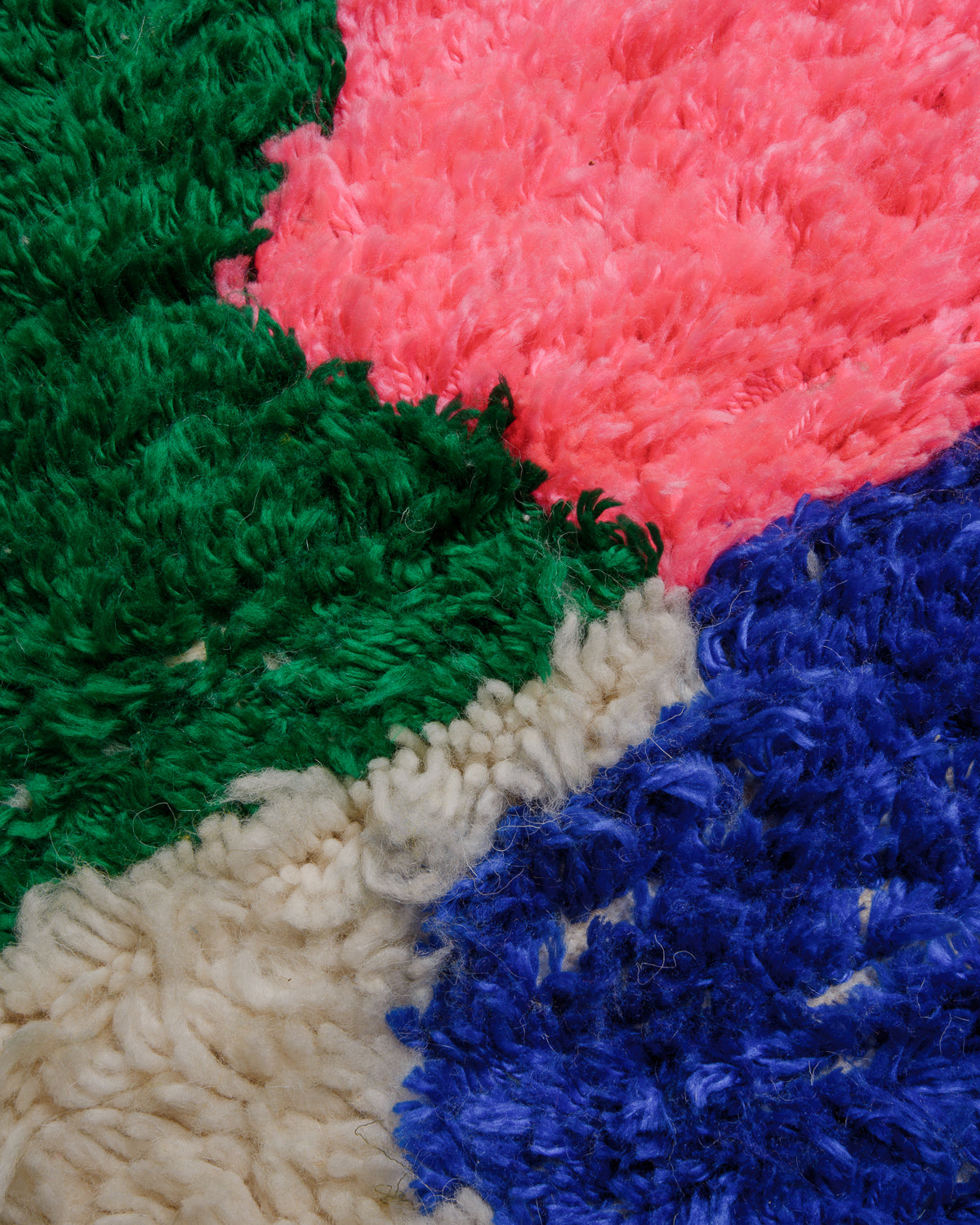 Close up of azilal rug with fluffy pink, blue and green.