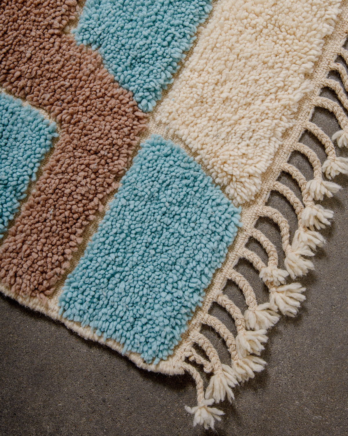 Corner of beniourain rug with natural wool tassels.