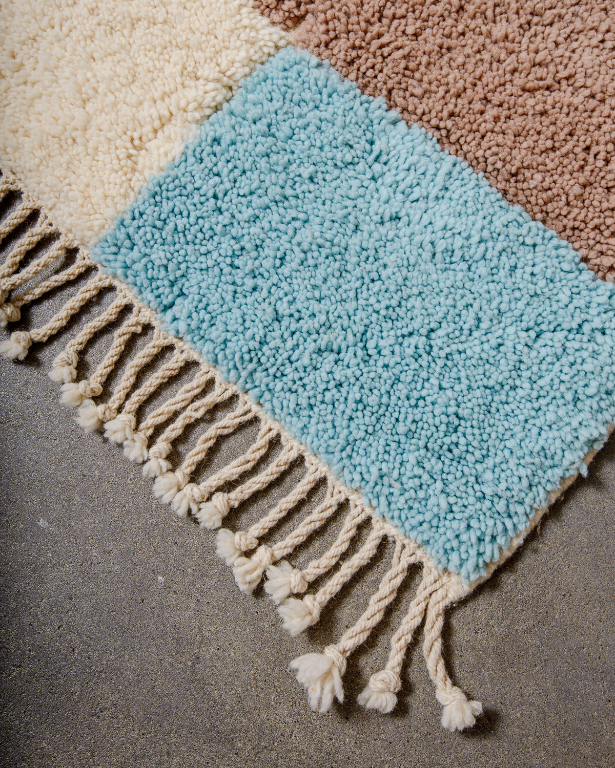 Corner of beniourain rug with natural wool tassels.