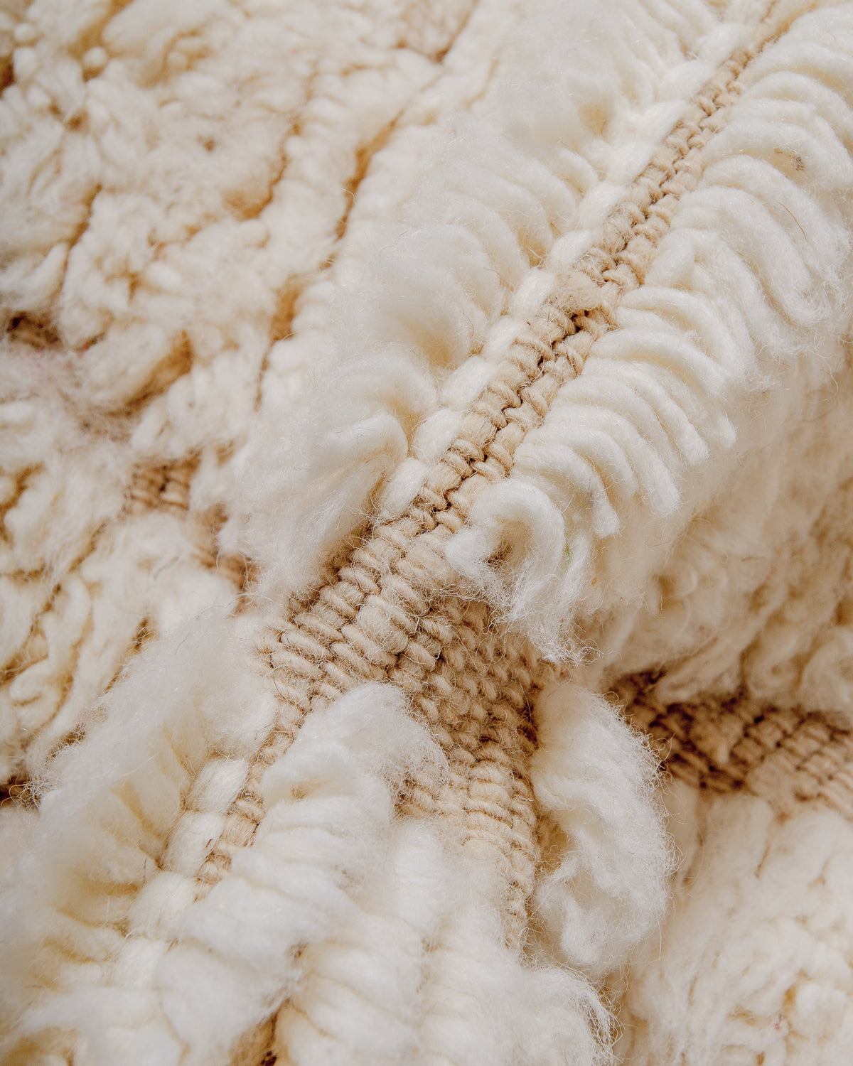 Close up of fluffy cream wool pile of Beniourain rug.