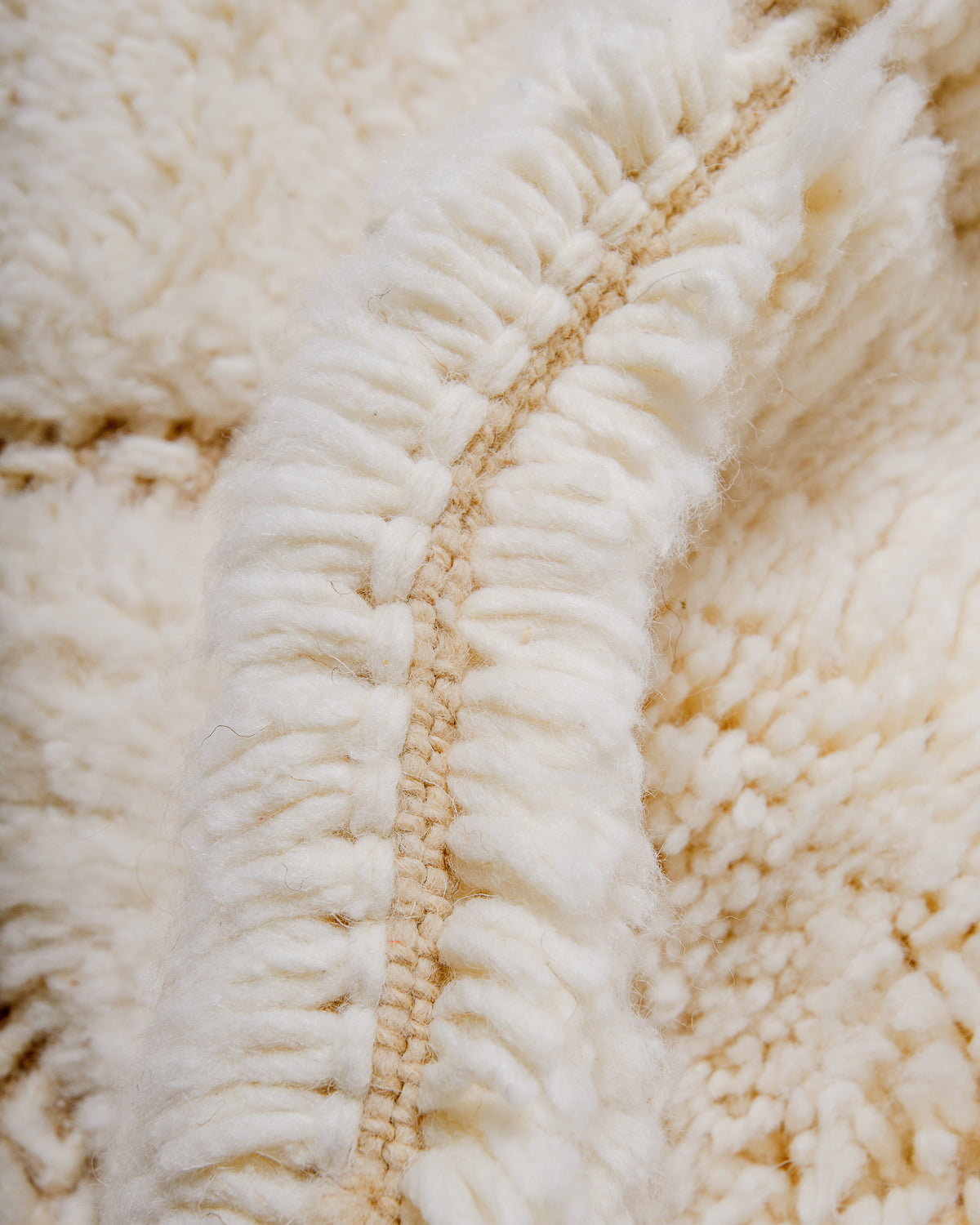 Close up of fluffy cream wool pile of Beniourain rug.