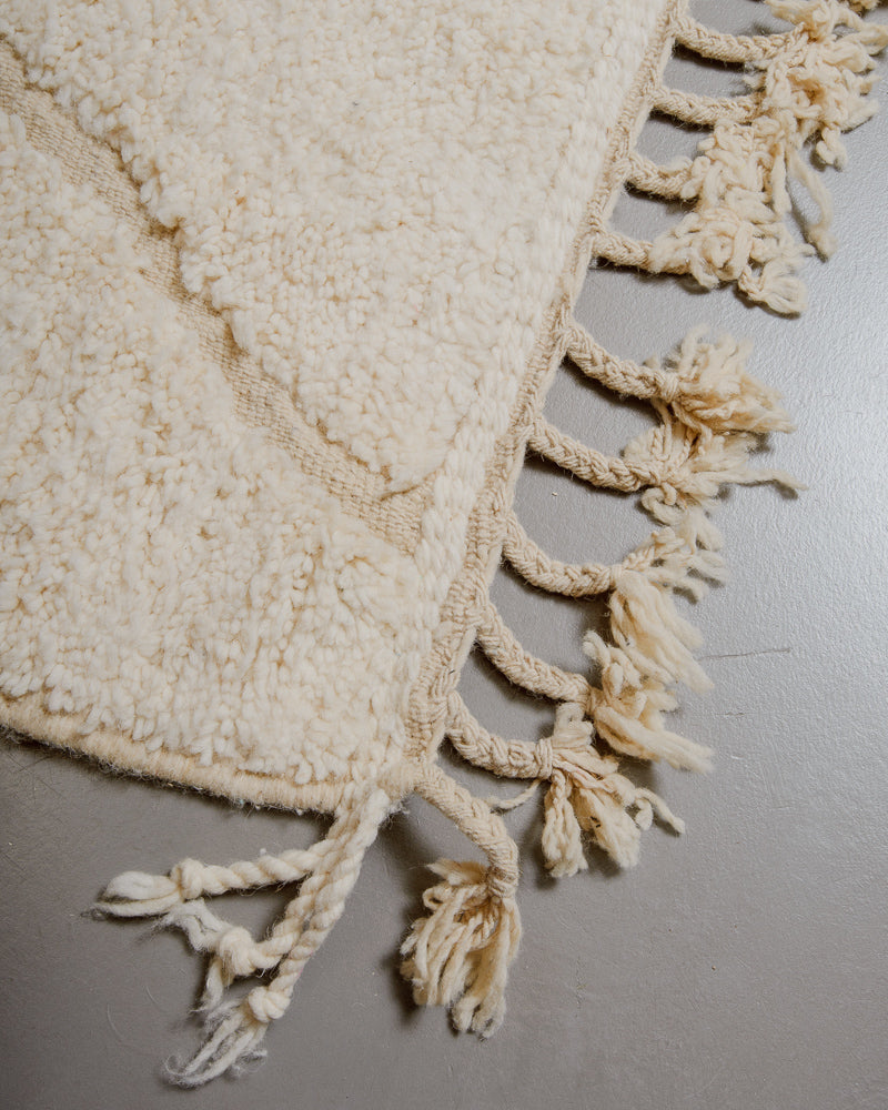 Corner of wool rug with natural tassels.