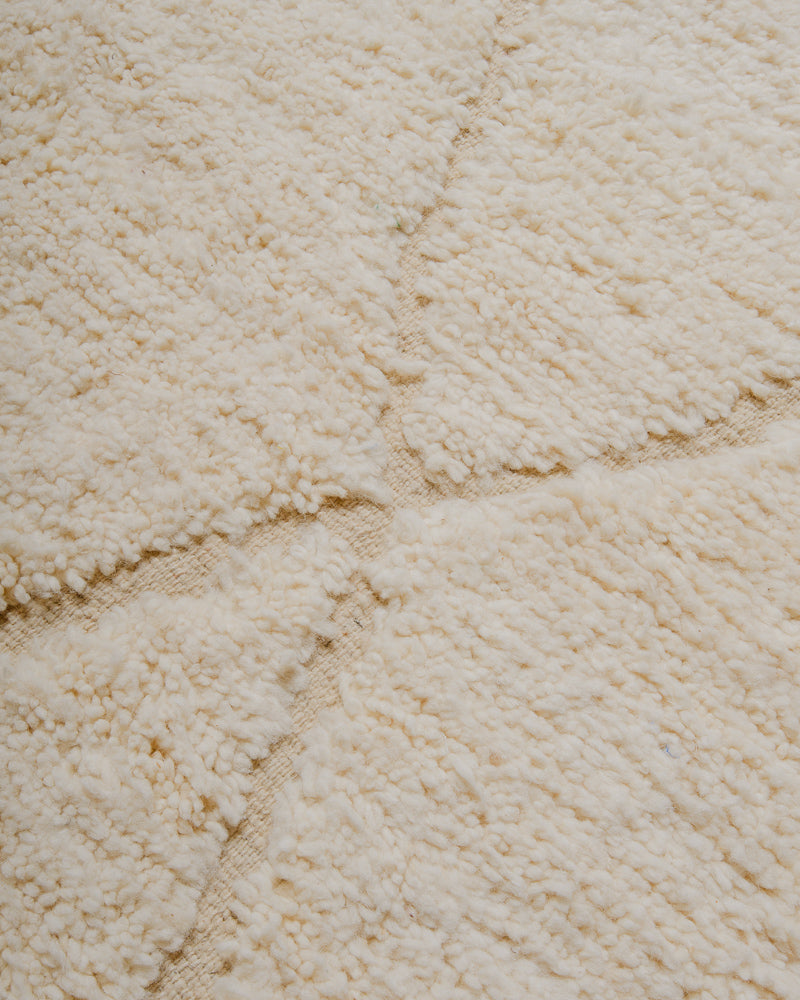 Surface of cream wool rug.