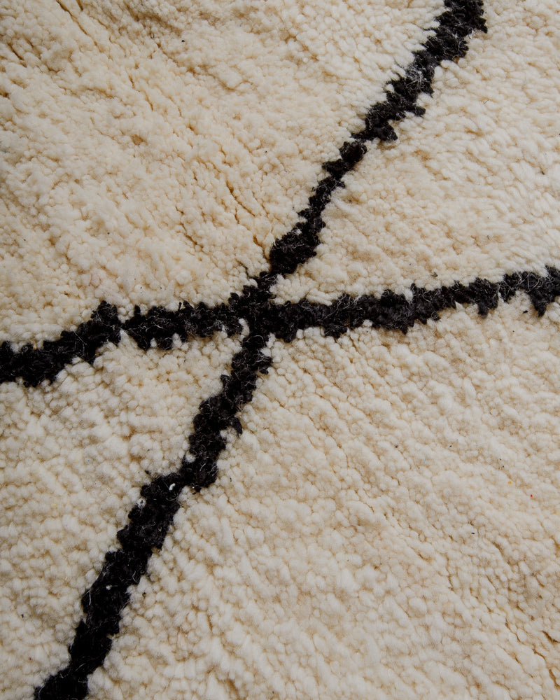 Surface of cream wool rug with thick black lines