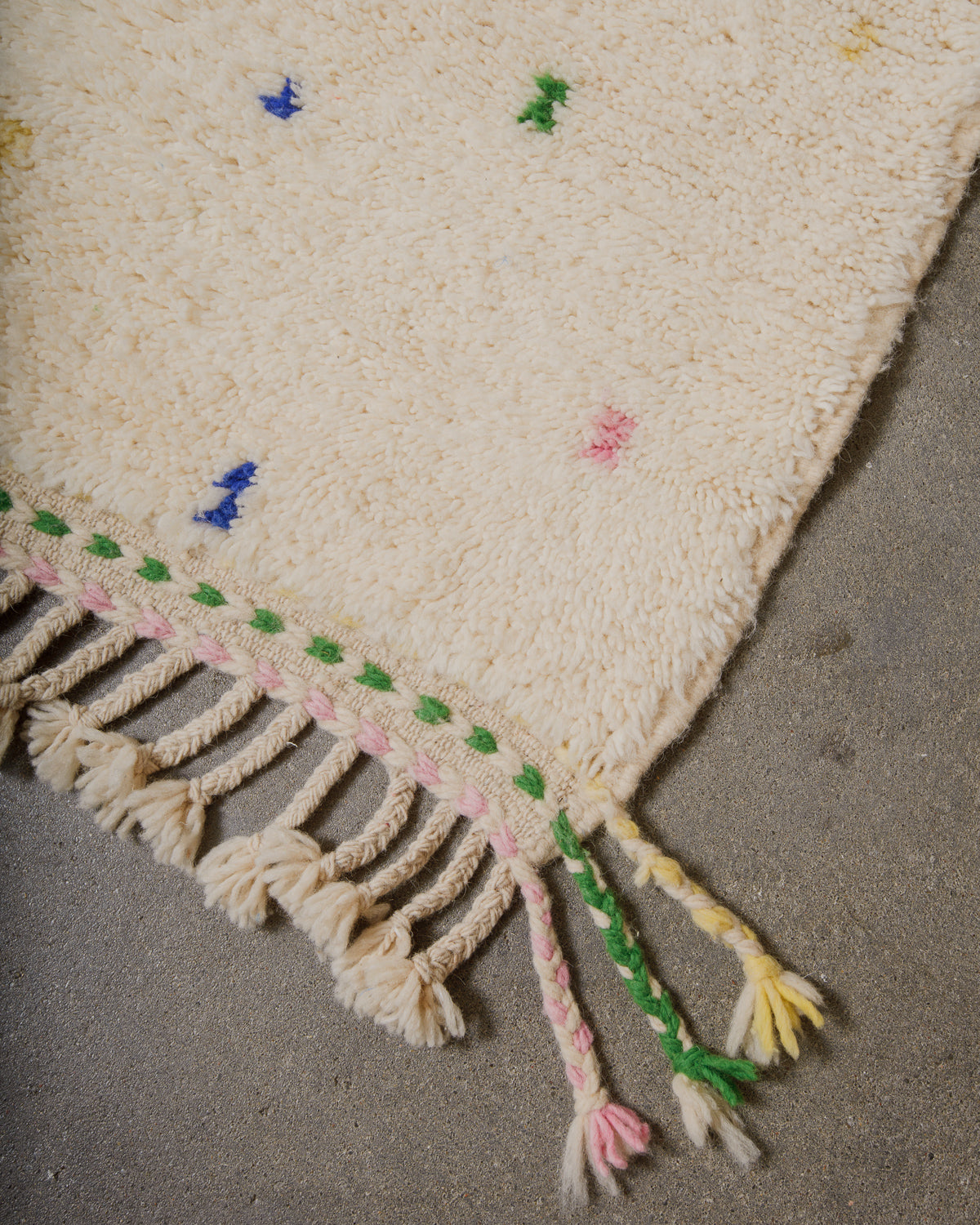 Berberlin rug with colorful tassels on a neutral background