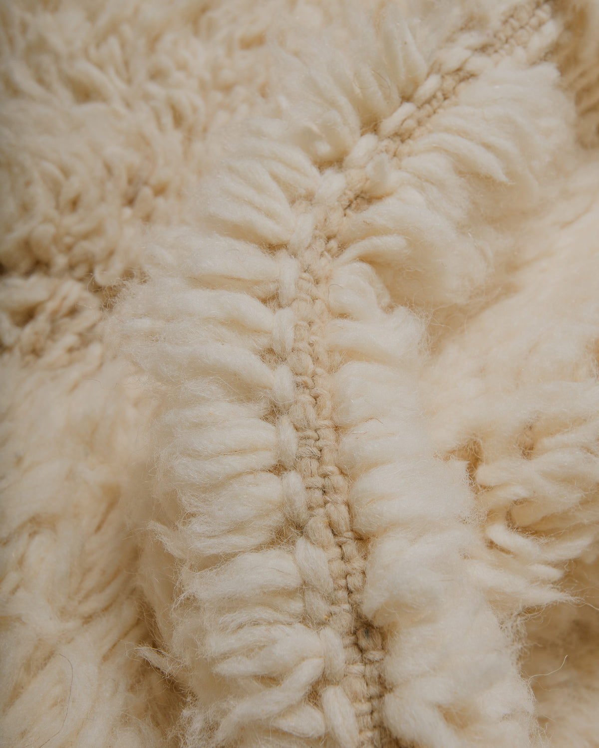 Close-up of a cream wool rug with fringes