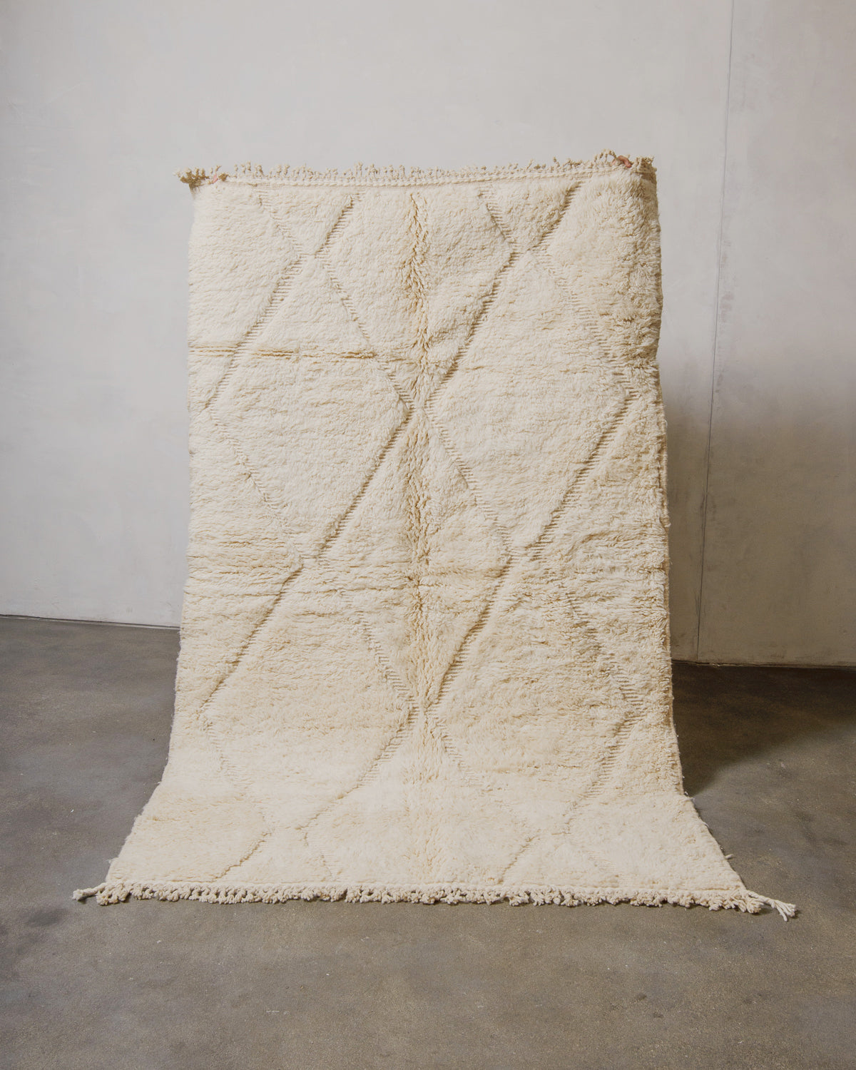 Beige textured rug on a plain background