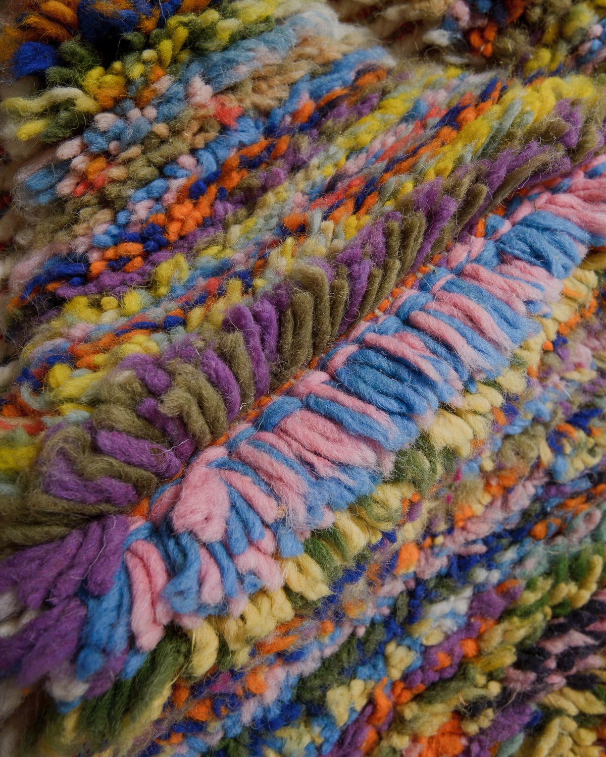 Close-up of a colourful rug with multicoloured yarn.