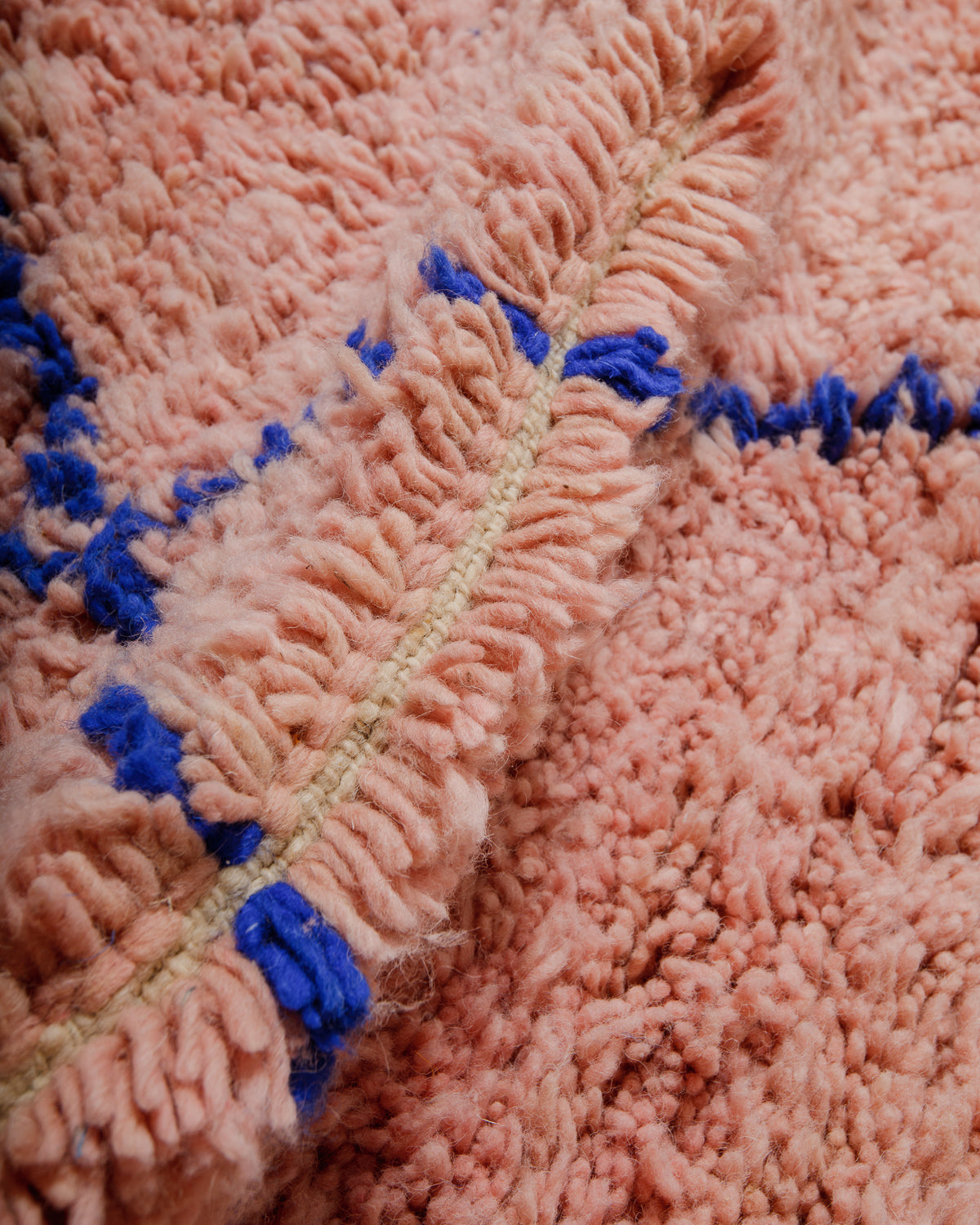 Detail shot of wool rug showing the knotting and length of pile. 