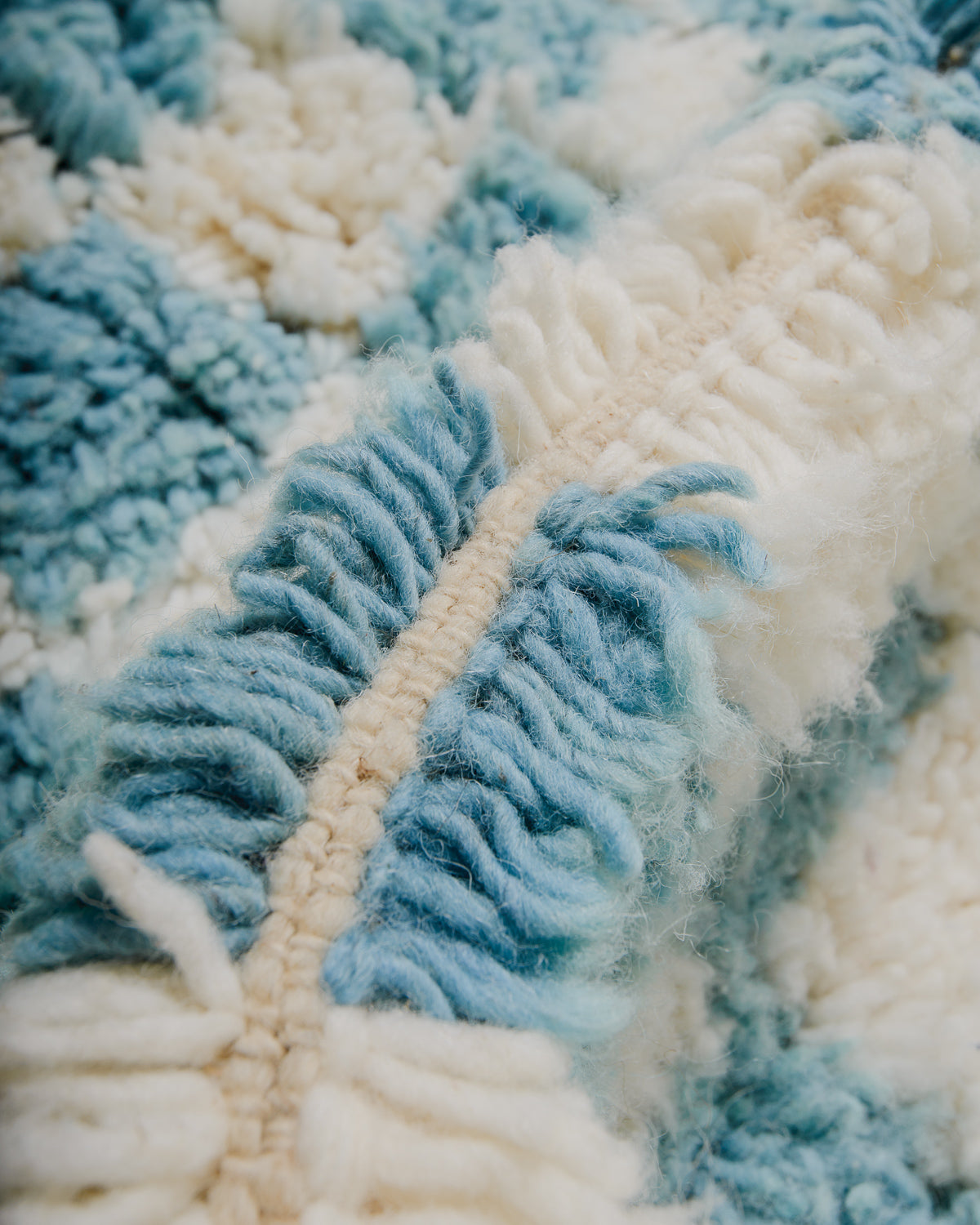 Close up of wool rug with thick pile in cream and robin's egg blue.