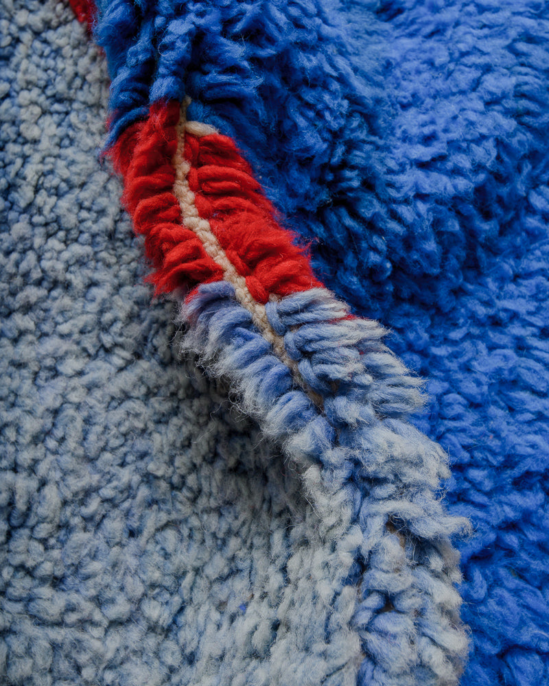 close up of fluffy wool rug with blue and red