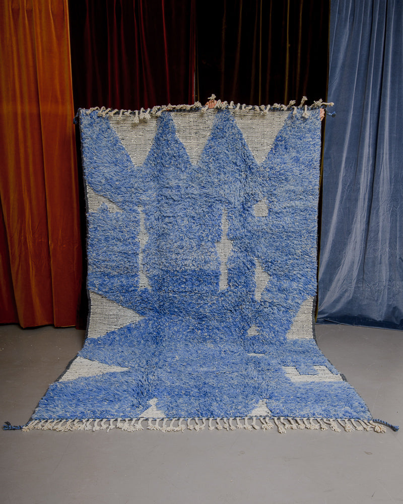 Berberlin Special Edition Beniourain rug  being held up against a velvet backdrop.