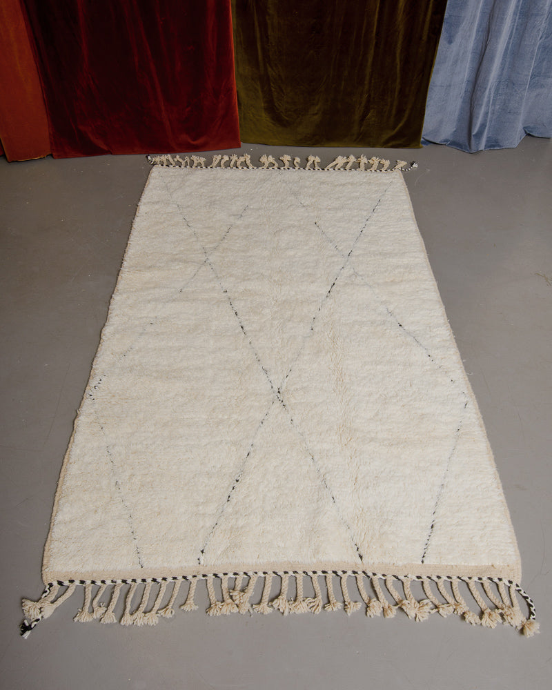 Berberlin Beniourain rug in cream and black wool on grey floor.