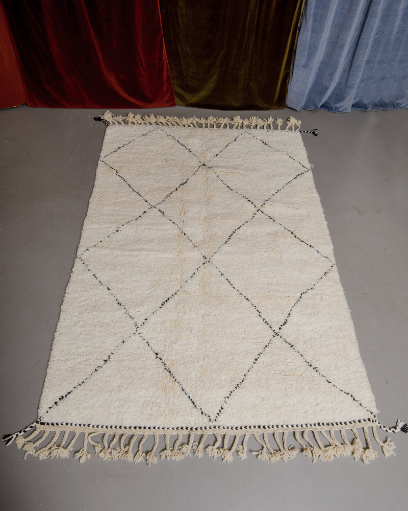 Berberlin Beniourain rug in cream and black wool on grey floor.