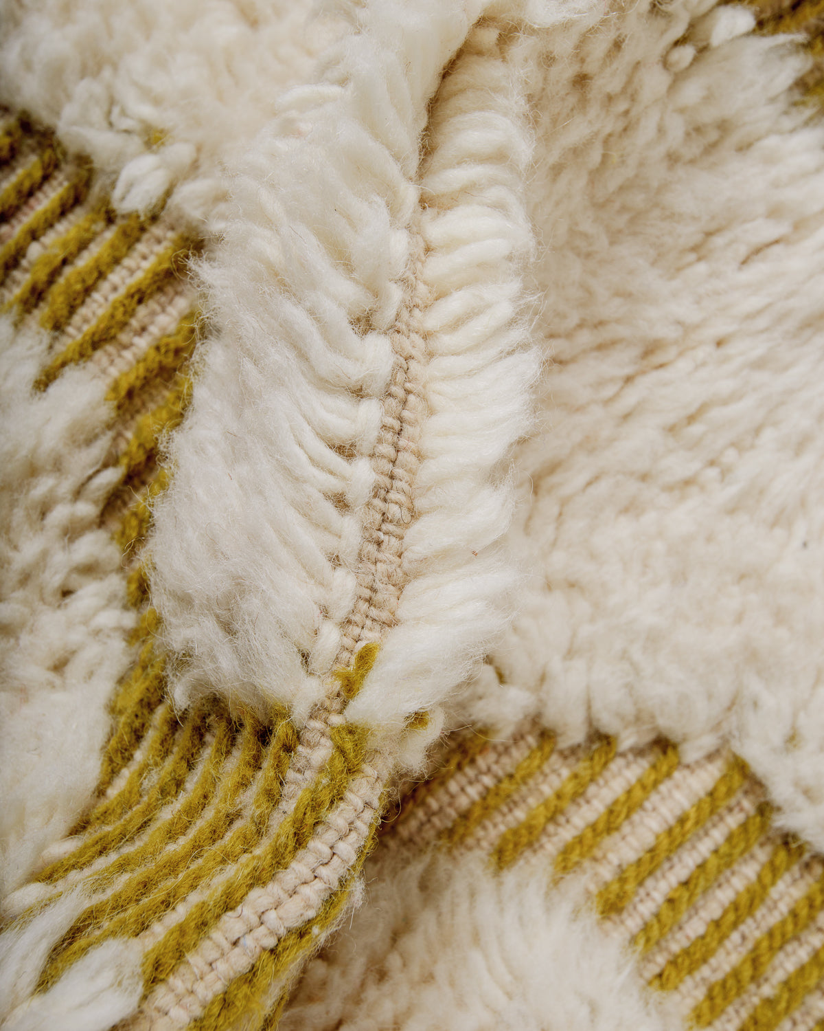 Close up of fluffy cream wool pile of Beniourain rug.