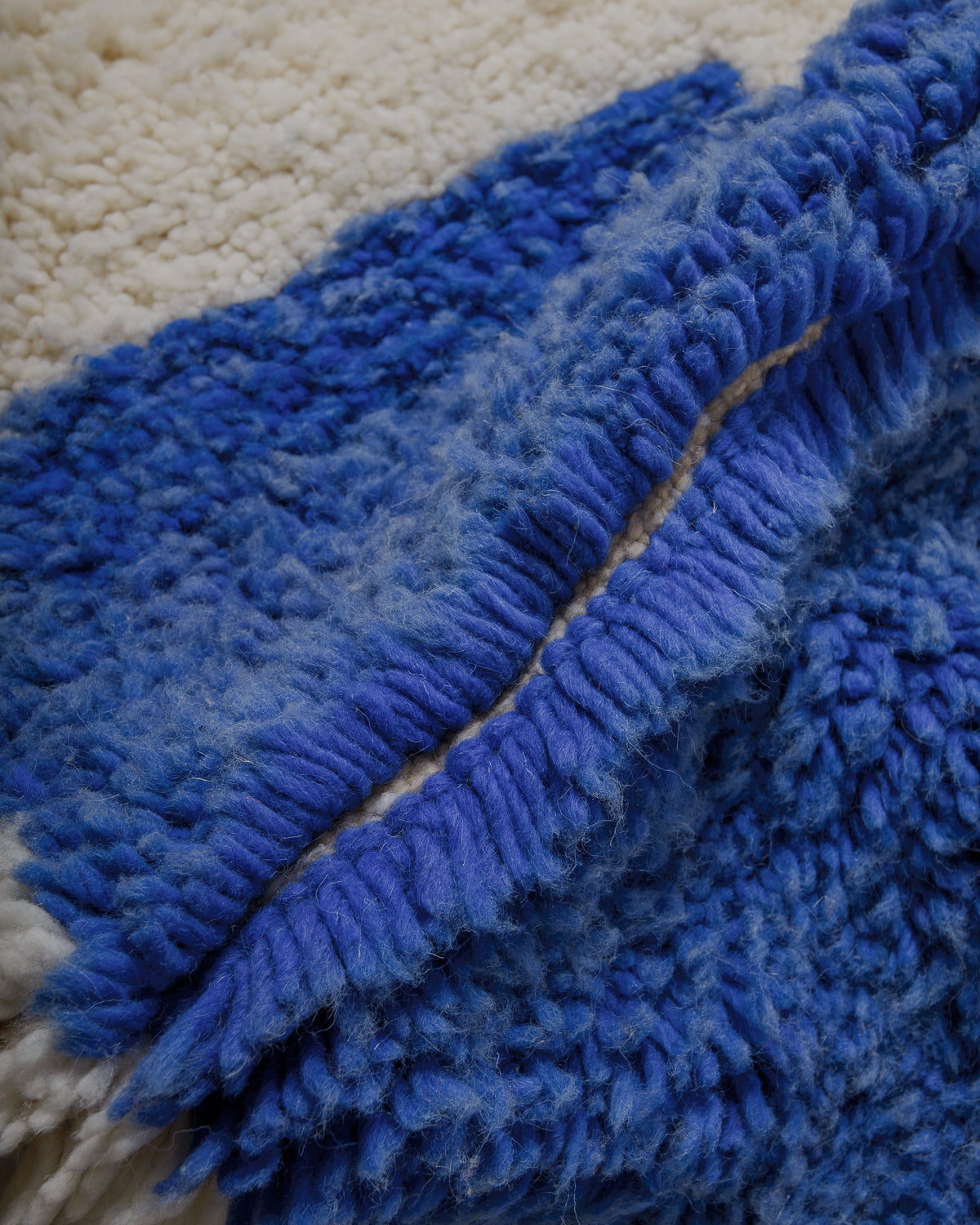 Close up of thick, fluffy blue and cream wool rug.