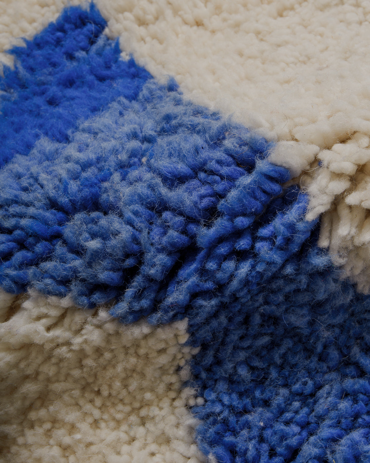 Close up of surface of blue and cream wool rug. 