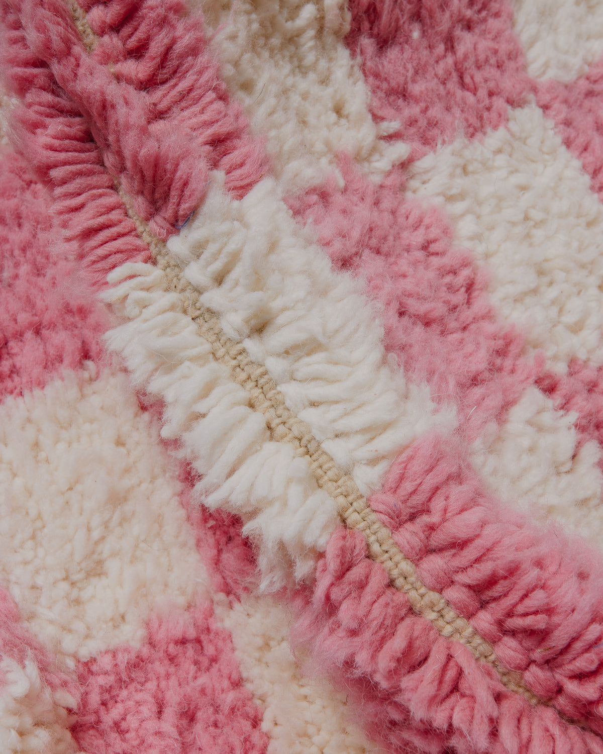 Close up of pink and cream checkered rug.