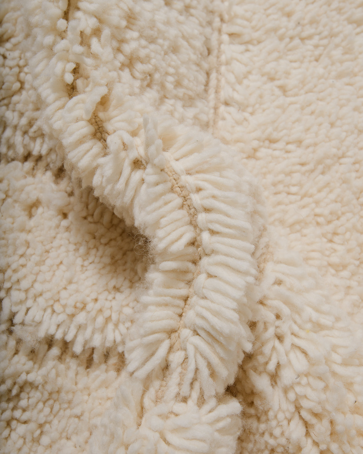 Close up of fluffy cream wool pile of Beniourain rug.
