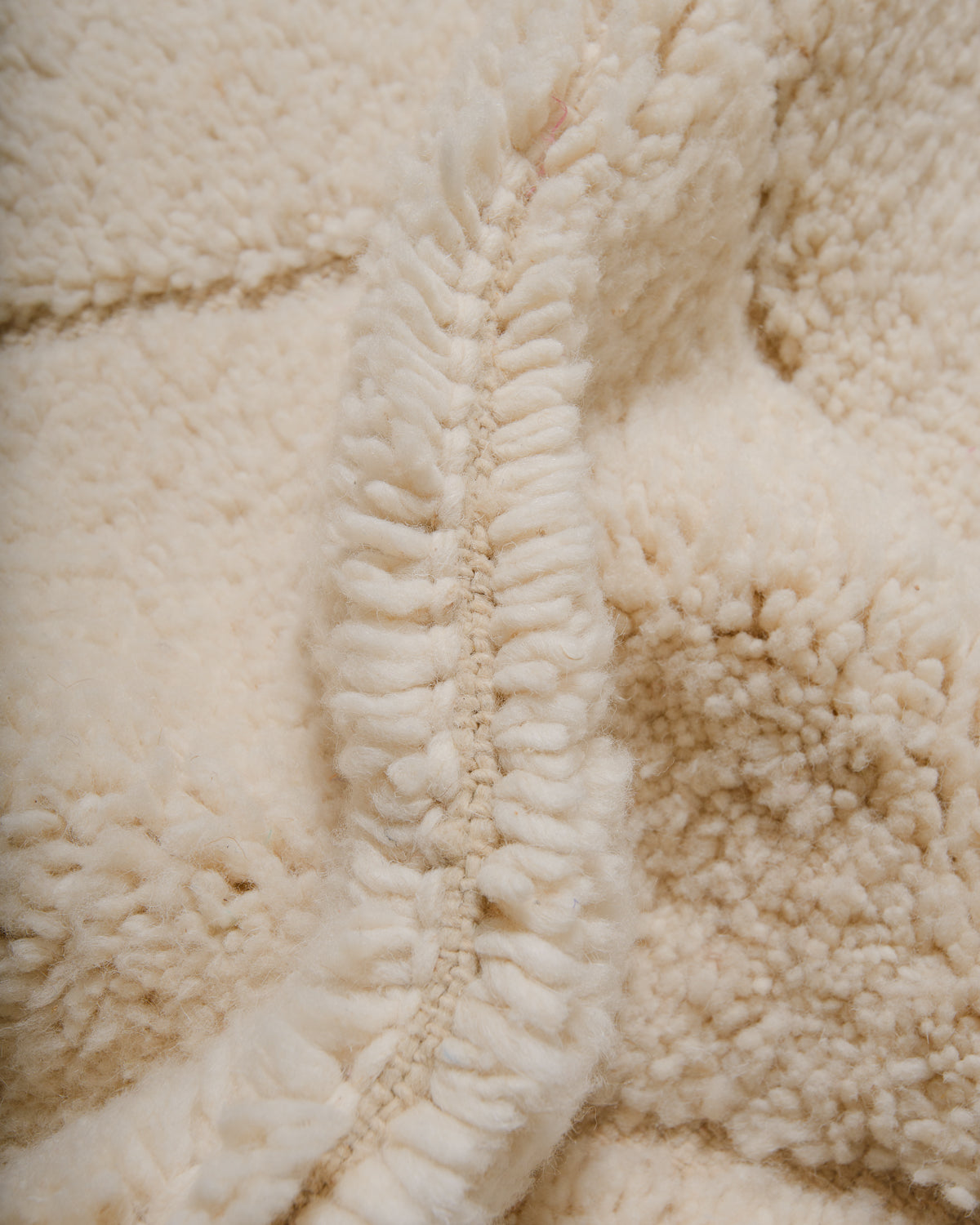 Close up of fluffy cream wool pile of Beniourain rug.