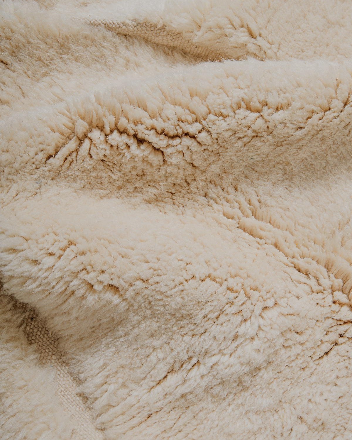Close-up of surface of cream wool rug.