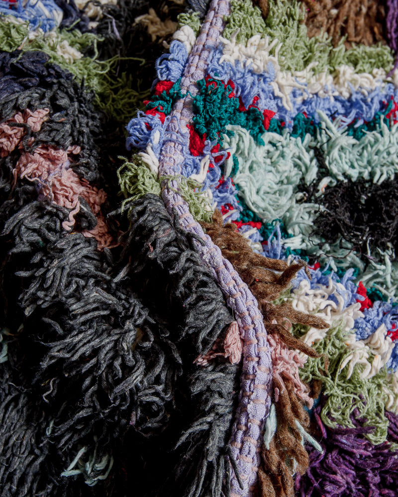 Close up of boucherouite rug with colourful cotton and fabric remnants and brown wool.
